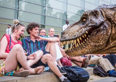 Photo of a crowd reacting to a dinosaur at a London event
