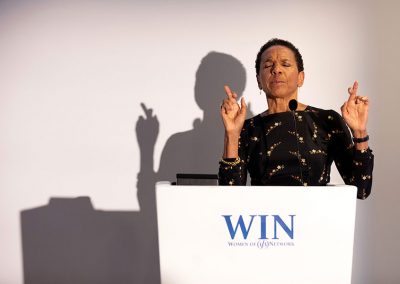 A business lady crosses her fingers at a event podium