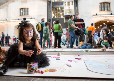a young girl plays with crayons on the floor at a london event
