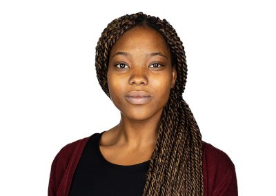A corporate headshot of a young black lady looking confidently to the camera
