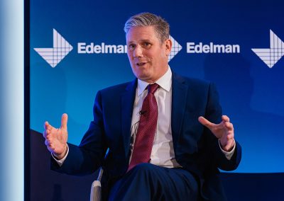 Sir Keir Starmer presents a business speech in front of a corporate banner