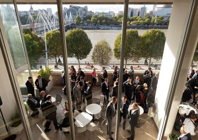 A wide angle photograph of a business gathering with the view of London in the background
