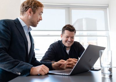 Two men look at a laptop planning their business company strategy