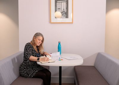 A lady sits a table writing a corporate document in her London office